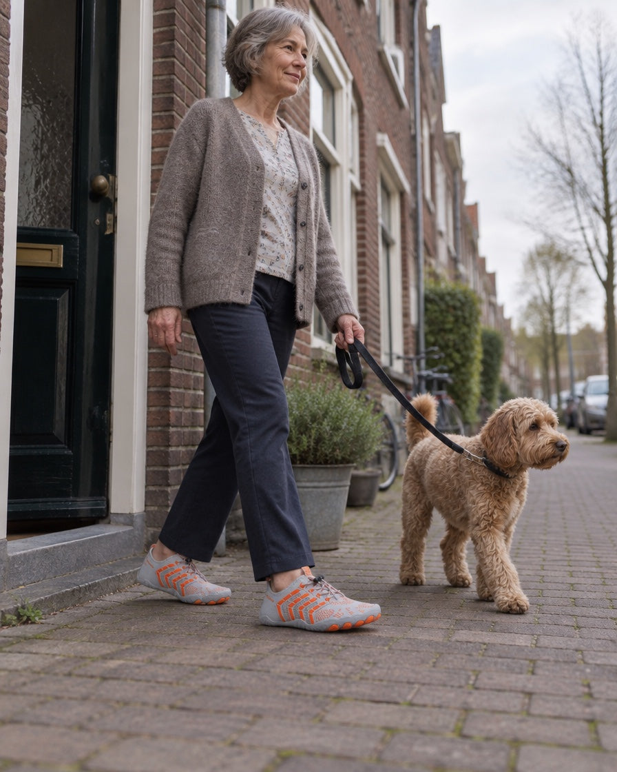 Vrouw loopt met de hond over straat in de Norvaflex Ridge